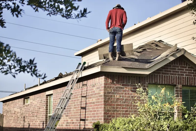 Professional roofer working on a residential roof in Vermont-Slauson